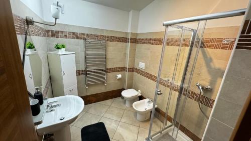 uma casa de banho com um chuveiro, um WC e um lavatório. em Eva Guest house apartment em Marino