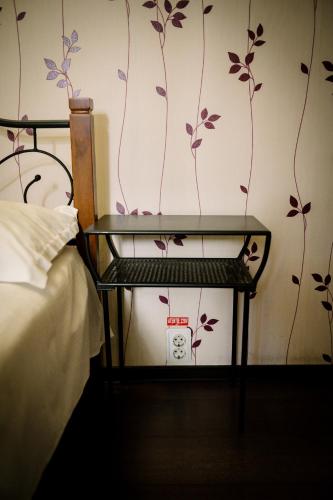 a bedroom with a bed and a table with a clock at Class in Petroşani