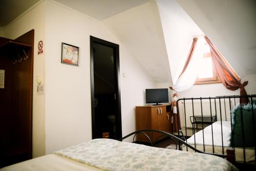 a bedroom with a bed and a window and a television at Class in Petroşani