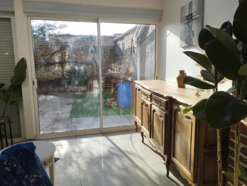 een keuken met een groot raam met uitzicht op een tuin bij Charmante maison proche de toutes commodités in Croix