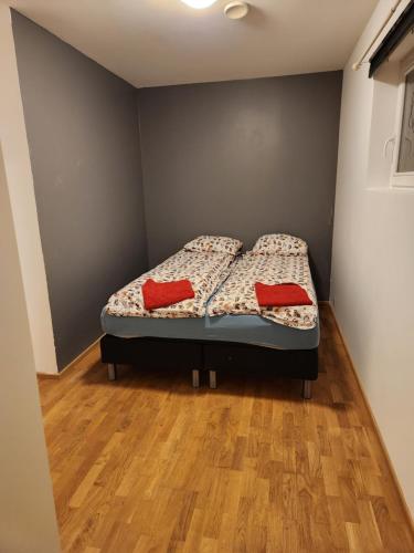 een slaapkamer met een bed met twee rode kussens erop bij Feelhome Borgtun One bedroom cozy apartment in Tromsø