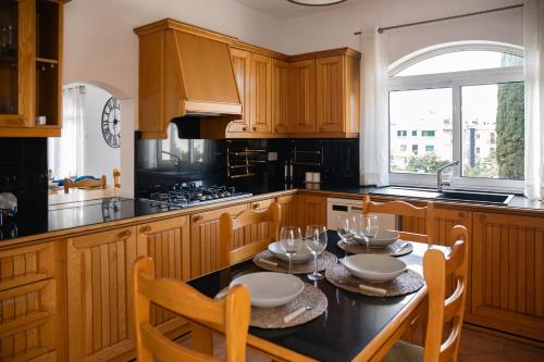 una cocina con armarios de madera y una mesa con sillas. en Villa in St Julian's with Private Pool en St Julian's