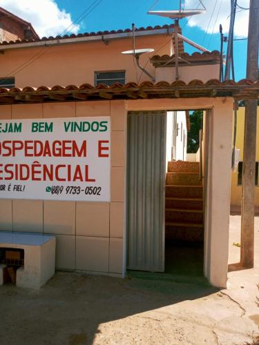 un edificio con un cartello sul lato di Hospedagem Domiciliar a Viçosa do Ceará