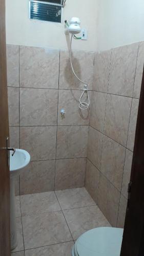 ein Bad mit einer Dusche, einem WC und einem Waschbecken in der Unterkunft Hospedagem Domiciliar in Viçosa do Ceará