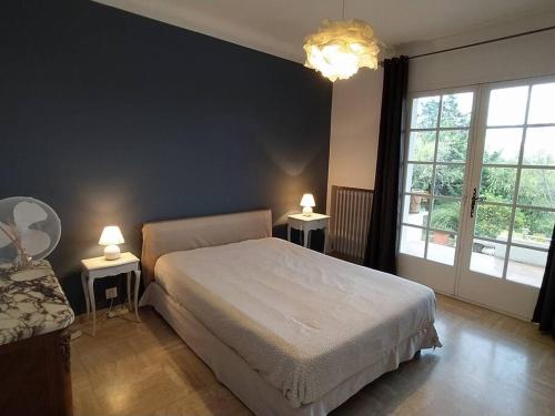 - une chambre avec un lit et 2 tables avec des lampes dans l'établissement Villa Lou Mazet - Piscine privée, à Saint-Raphaël