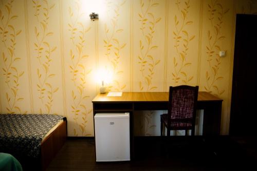 a desk in a room with a bed and a chair at Class in Petroşani