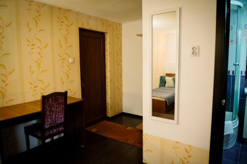 a room with a desk and a chair and a mirror at Class in Petroşani