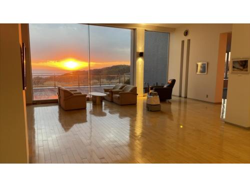 a living room with couches and a view of a sunset at Shonan Relief - Vacation STAY 50852v in Yokosuka