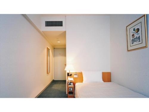 Habitación de hotel con cama y lámpara en Shonan Relief - Vacation STAY 50853v en Yokosuka