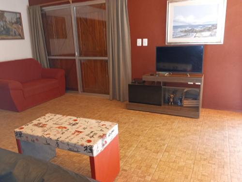sala de estar con sofá y TV en Entre naturaleza a 1 cuadra de la playa/Jacuzzi en Salinas 
