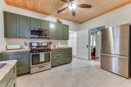 a kitchen with green cabinets and a ceiling fan at Baton Rouge Cottage with Fenced Yard Near Downtown! in Baton Rouge