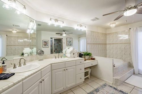 uma casa de banho com 2 lavatórios, uma banheira e um espelho grande em Camp Sandy Lakefront, Pool,H Tub, Sand Volleyball em Austin
