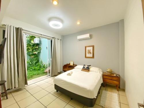 a bedroom with a bed and a large window at Edificio Teocalli, Bacocho Puerto Escondido in Puerto Escondido