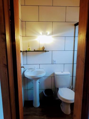 a bathroom with a toilet and a sink at Chalé do Budha in Torres