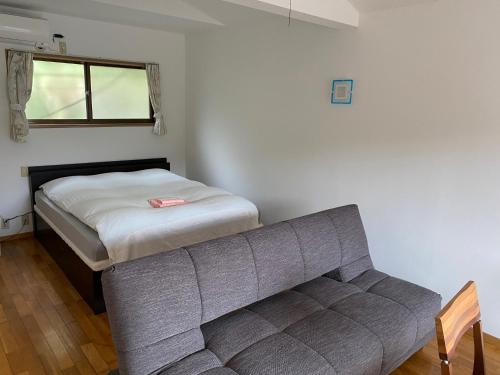 um sofá num quarto com uma cama e uma janela em Lilac Hotels and Resorts - Vacation STAY 53232v em Kanoya