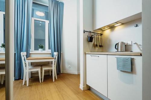 a kitchen with a table and a small table and chairs at Stylish Central Apartment - 5 mins to Old Town in Riga