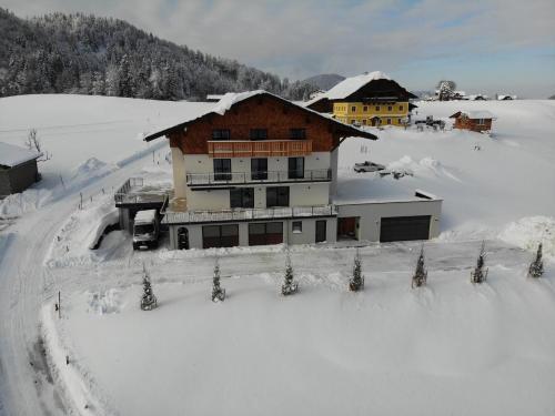 a large building in the snow with snow at Apartment Tanzberger in Faistenau
