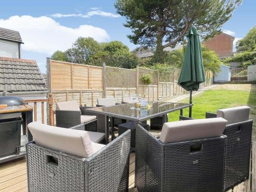a patio with a table and chairs and an umbrella at Home AWey - Holiday home near harbour in Weymouth