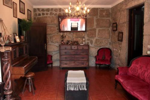 a living room with a couch and a dresser and a piano at Casa de Marlães in Lousada
