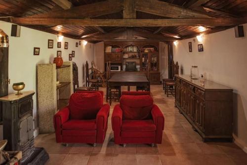 salon z 2 czerwonymi krzesłami i stołem w obiekcie Casa de Marlães w mieście Lousada