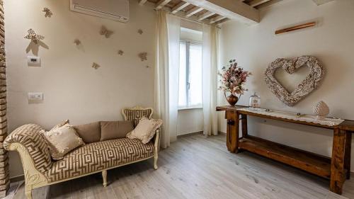 a living room with a couch and a heart on the wall at Casa Tarducci in Urbania