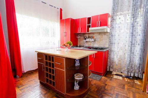 una cocina con armarios rojos y una isla en una habitación en Villa Fialofana Ambohimarina, 