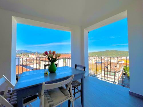 巴里薩爾多的住宿－Le Corti Sarde Apartments，阳台上的蓝色桌子和花瓶