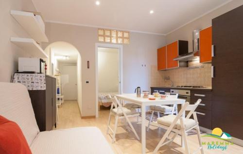 eine Küche und ein Wohnzimmer mit einem Tisch und Stühlen in der Unterkunft Maremma Holidays:Pini Apartment in Follonica