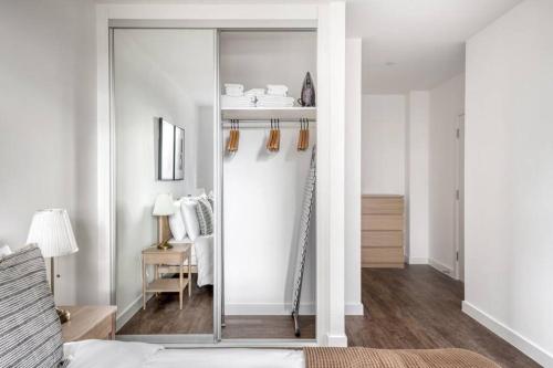 a bedroom with a mirrored closet with a bed and a desk at Luxurious 2 Bedroom Central Flat in Leicester