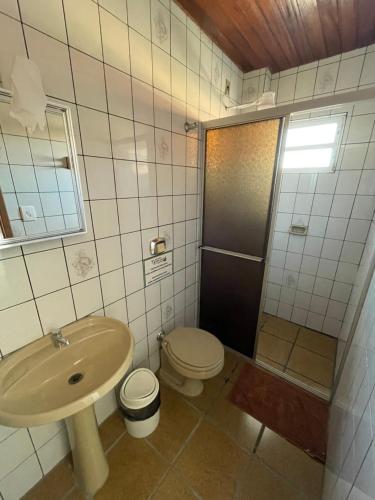 a bathroom with a sink and a toilet and a shower at Pousada Vera Lucia in Guarda do Embaú