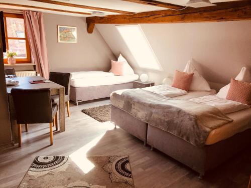 Schlafzimmer mit einem Bett, einem Tisch und einem Schreibtisch in der Unterkunft Hotel Nürnberger Hof in Altdorf in Altdorf bei Nürnberg