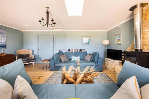 a living room with a blue couch and a fireplace at Stunning Renovation edge of Frome + country views in Frome