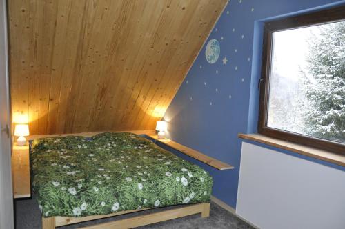 a bedroom with a bed and a window at Cataleya Rajcza in Rajcza