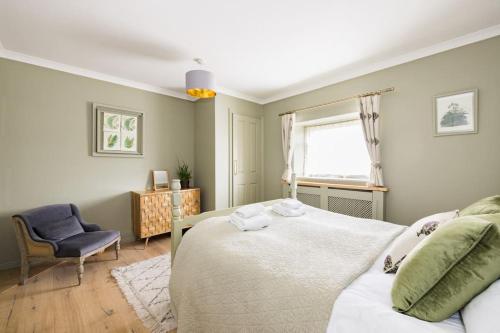 a bedroom with a bed and a chair and a window at Stunning Renovation edge of Frome + country views in Frome