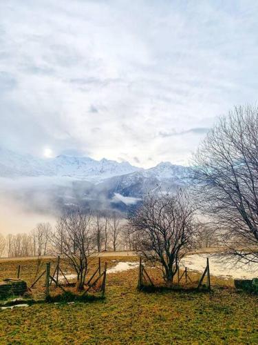 a fence in a field with mountains in the background at Rustico Valgrazia in Molare