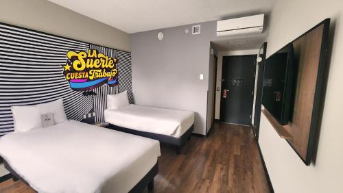 a room with two beds and a sign on the wall at ibis styles Lima San Isidro in Lima