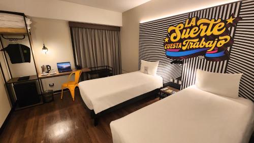 a hotel room with two beds and a desk at ibis styles Lima San Isidro in Lima
