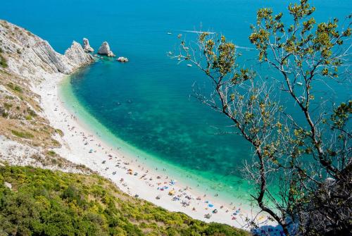 a group of people on a beach near the ocean at Cascina del Poeta in Recanati