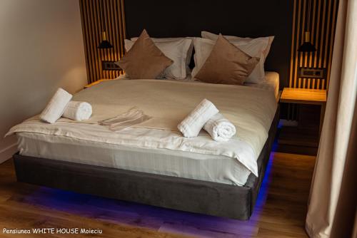 a bedroom with a bed with towels on it at White House Moieciu in Moieciu de Jos