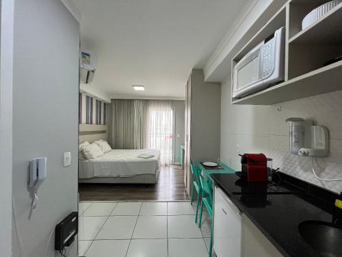 um quarto com uma cozinha e um quarto com uma cama em MH 50402 - Lindo Studio Expo CN WF/AC/VG em São Paulo