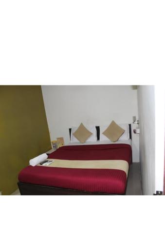 1 dormitorio con 1 cama con sábanas rojas y blancas en Hotel saffron inn, en Bombay