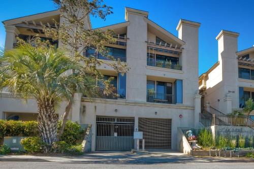 a building with a palm tree in front of it at Oceanfront, Luxury Remodel, Pool, Walk To Dining in Encinitas