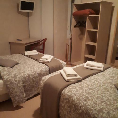 a room with three beds with towels on them at HOTEL RESTAURANT LE CENTRE in Comblanchien