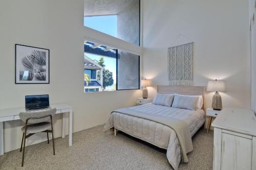 a bedroom with a bed and a desk and a window at Oceanfront, Luxury Remodel, Pool, Walk To Dining in Encinitas