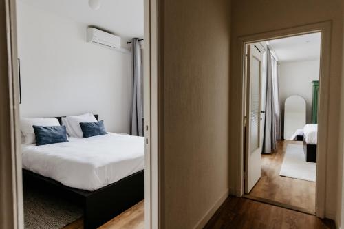 a bedroom with a bed and a hallway with a mirror at Cathedral view apartment in Antwerp