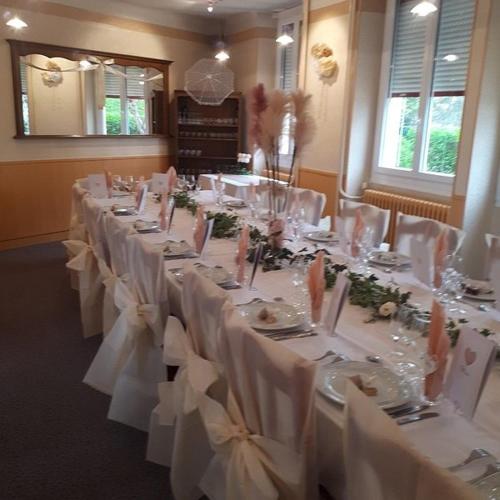 a room with a long table with white tablecloths and flowers at HOTEL RESTAURANT LE CENTRE in Comblanchien