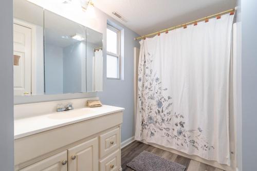 a bathroom with a sink and a shower curtain at Amazing sunsets, dock, fire pit, lily pad in Lake Ozark