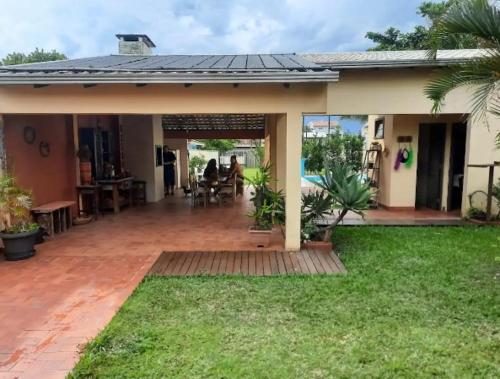 a house with a patio and a yard at PARAISO FAMILIAR- Piscina- Pontal do Sul - PR in Pontal do Paraná