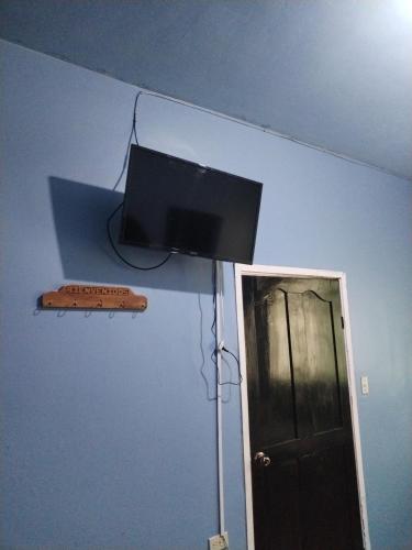 einen Flachbild-TV an einer Wand neben einer Tür in der Unterkunft Hotel 24 /7 in Comayagua