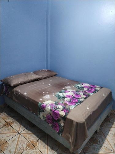 Una cama con flores en una habitación en Hotel 24 /7, en Comayagua